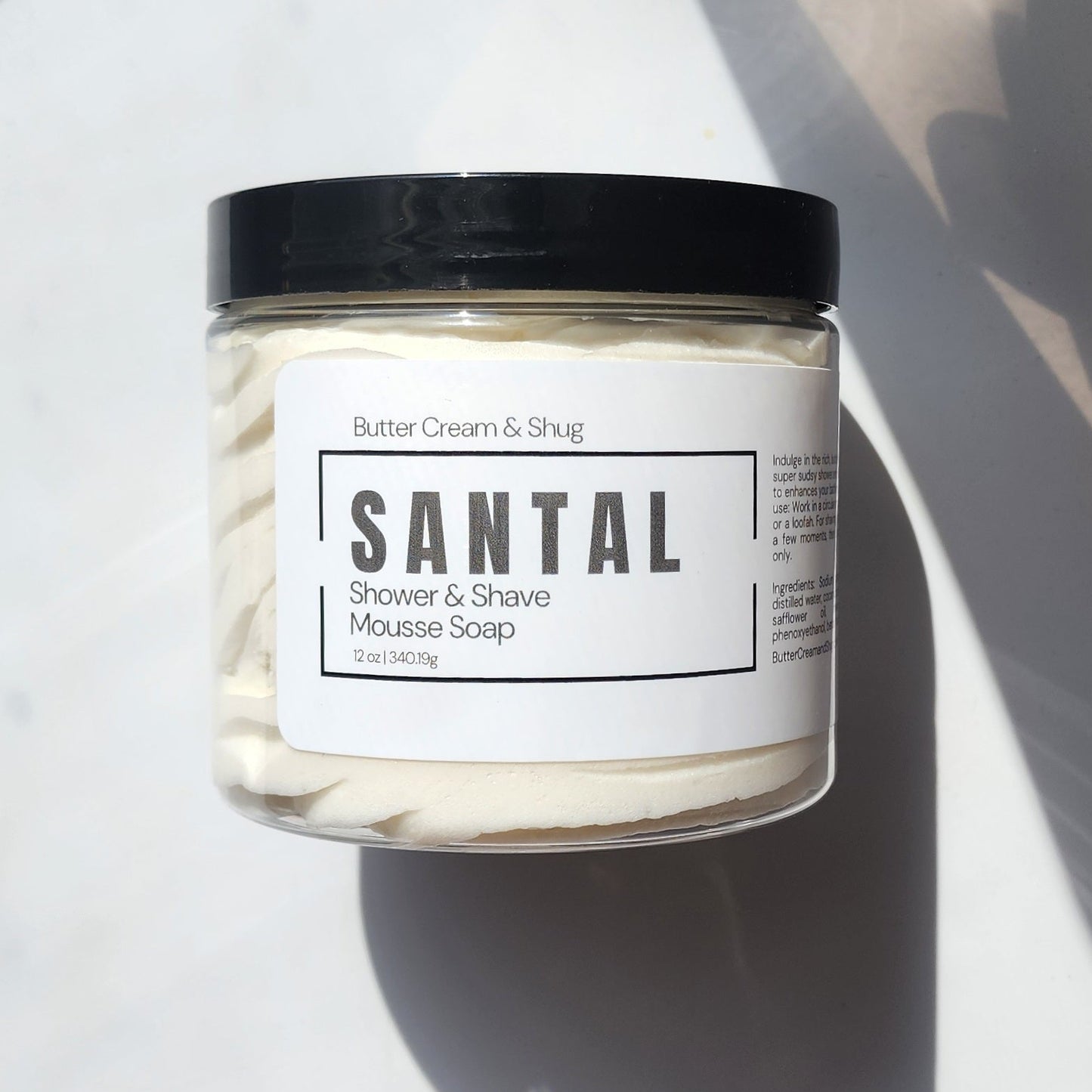 Jar of Santal shower and shave mousse soap with a label on a light background